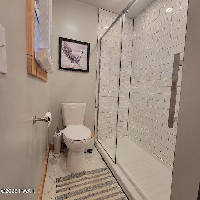 full bath with toilet, a shower stall, baseboards, and tile patterned flooring