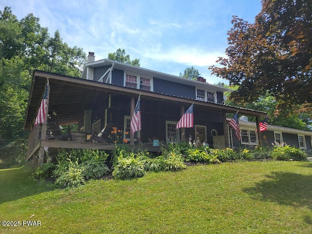 view of front facade with a chimney and a front yard