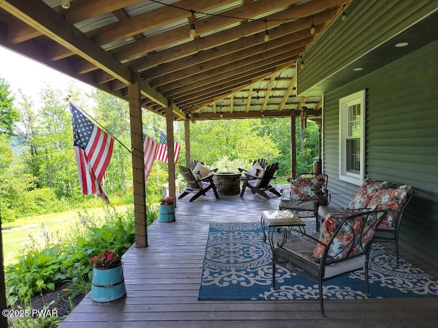 wooden deck featuring an outdoor living space with a fire pit