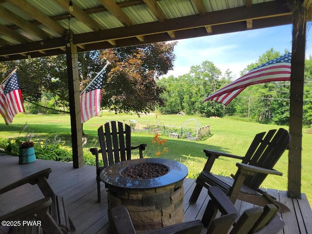 deck with an outdoor fire pit and a lawn