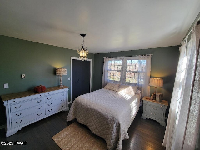 bedroom with dark wood-style flooring and an inviting chandelier