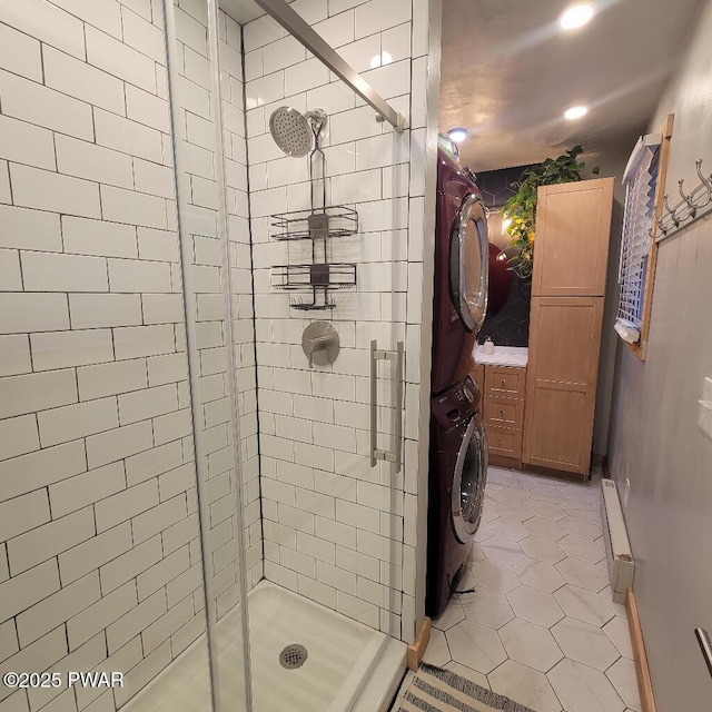 full bathroom featuring tile patterned flooring, a shower stall, and stacked washer / drying machine