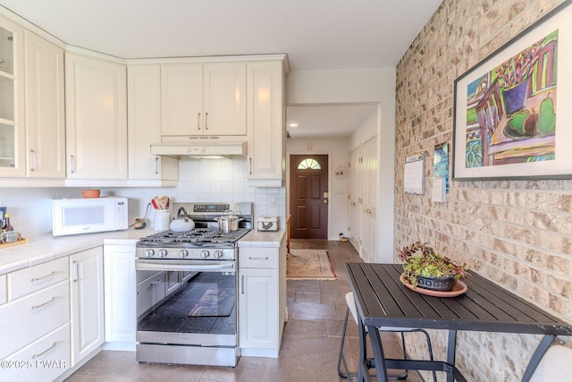 113 Jacobs Ladder Rd, Starrucca, PA 18462 - kitchen featuring stainless steel range with gas cooktop, under cabinet range hood, white microwave, tile counters, and white cabinets