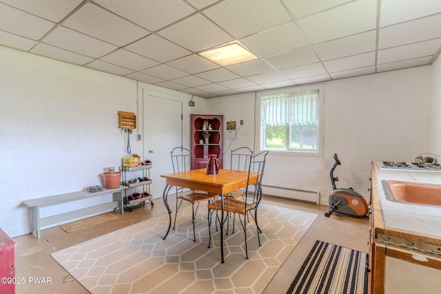 113 Jacobs Ladder Rd, Starrucca, PA 18462 - dining space featuring a baseboard heating unit, concrete block wall, a paneled ceiling, and concrete flooring
