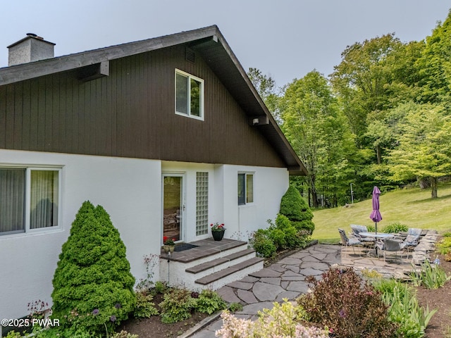113 Jacobs Ladder Rd, Starrucca, PA 18462 - rear view of house featuring a patio, a chimney, and stucco siding