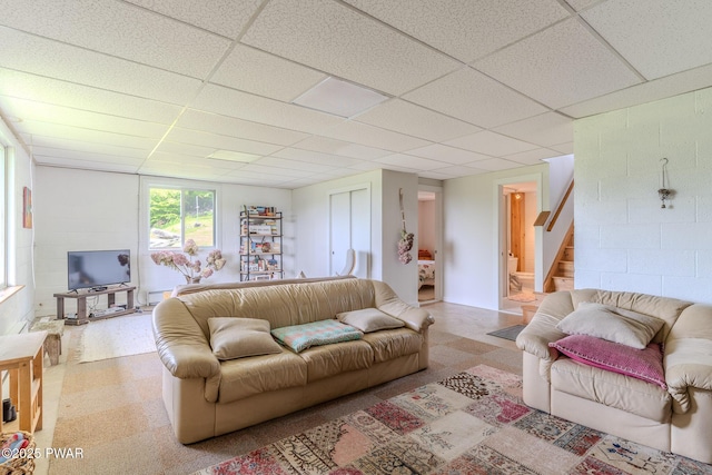113 Jacobs Ladder Rd, Starrucca, PA 18462 - living room featuring a drop ceiling, stairs, concrete block wall, and tile patterned floors