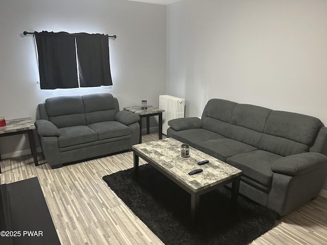 living area featuring radiator, light wood-style flooring, and baseboards