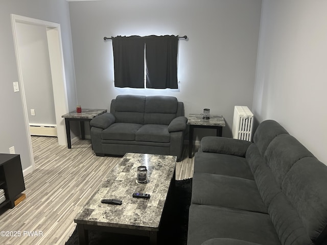 living room featuring radiator, light wood-style flooring, baseboards, and a baseboard radiator