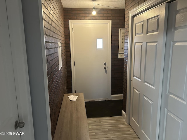 interior space with brick wall and wood finished floors