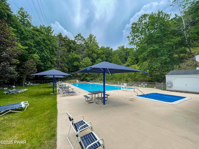 pool with a lawn, a patio, and fence