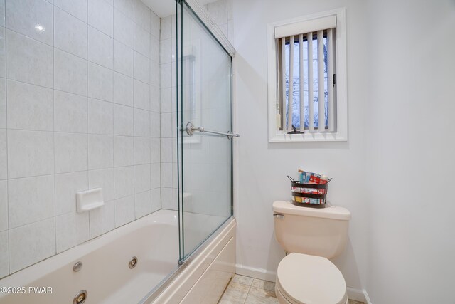 bathroom with tile patterned floors, baseboards, toilet, and a combined bath / shower with jetted tub