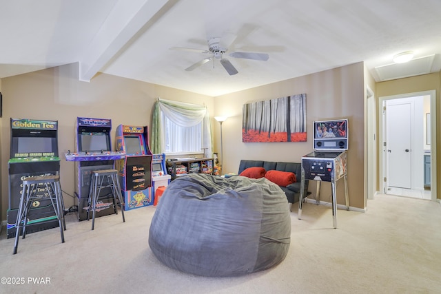 living area featuring carpet floors, baseboards, attic access, ceiling fan, and vaulted ceiling with beams