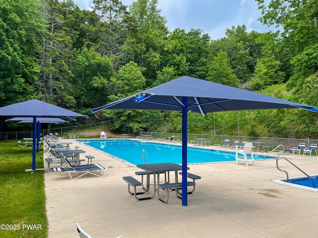 pool featuring fence and a patio area