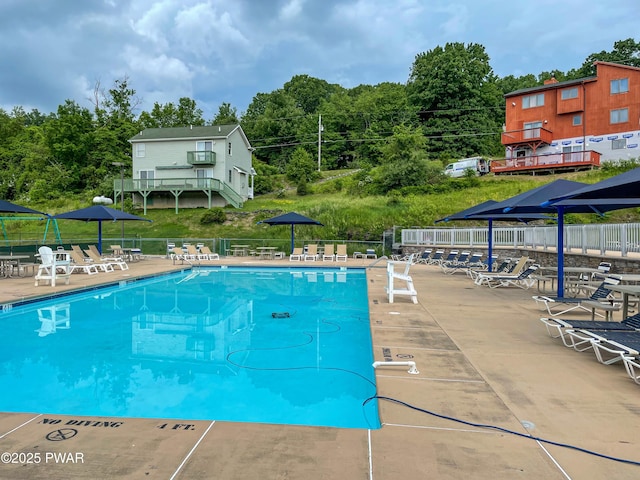 view of pool with a patio area and fence