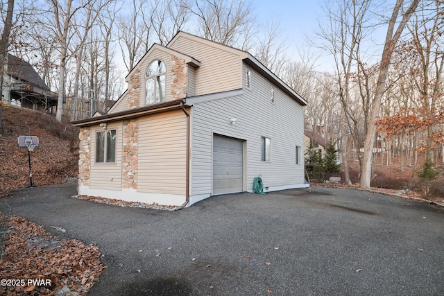 view of property exterior with a garage and driveway