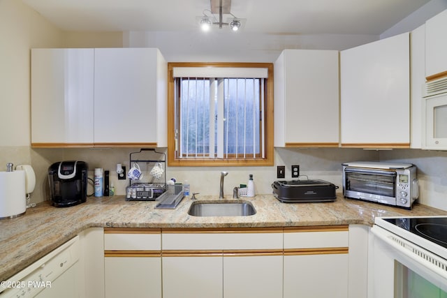 kitchen with a sink, white appliances, white cabinets, and a toaster