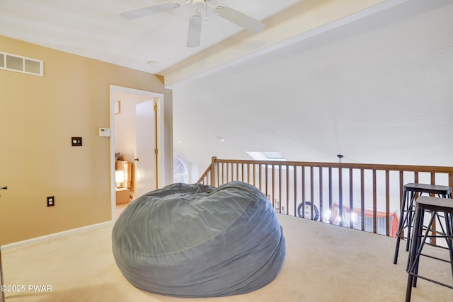 sitting room featuring visible vents, baseboards, beamed ceiling, carpet floors, and a ceiling fan