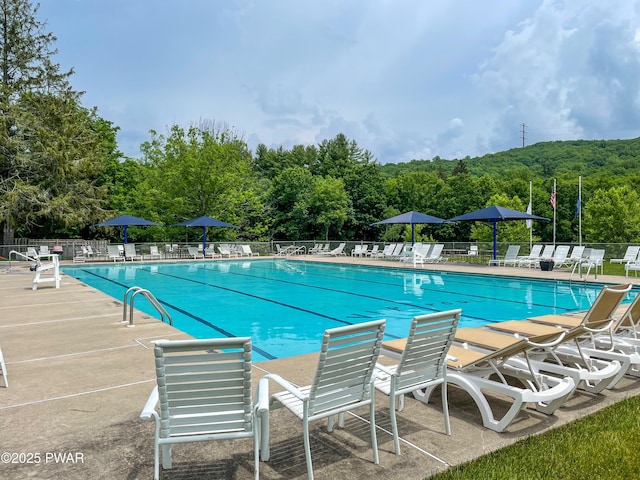 pool with a patio and fence