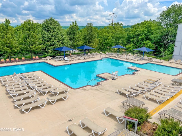 community pool with a patio and fence