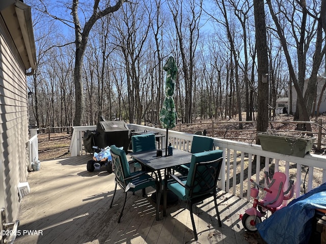 deck with grilling area and outdoor dining area