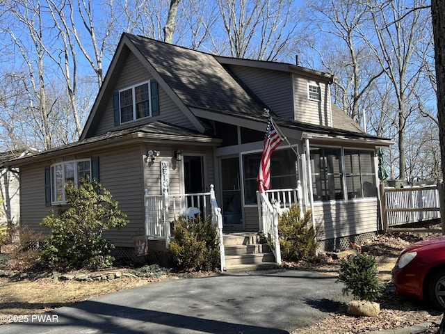 view of front of house with roof with shingles and a sunroom