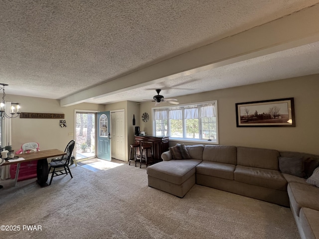 carpeted living area featuring a notable chandelier and a textured ceiling