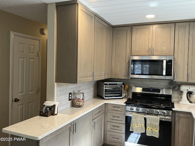 kitchen featuring a toaster, decorative backsplash, stainless steel appliances, and light stone countertops