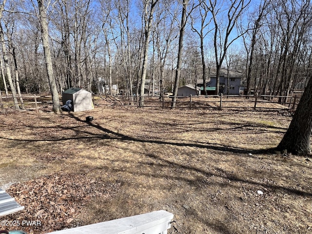 view of yard with an outbuilding, a storage shed, and fence