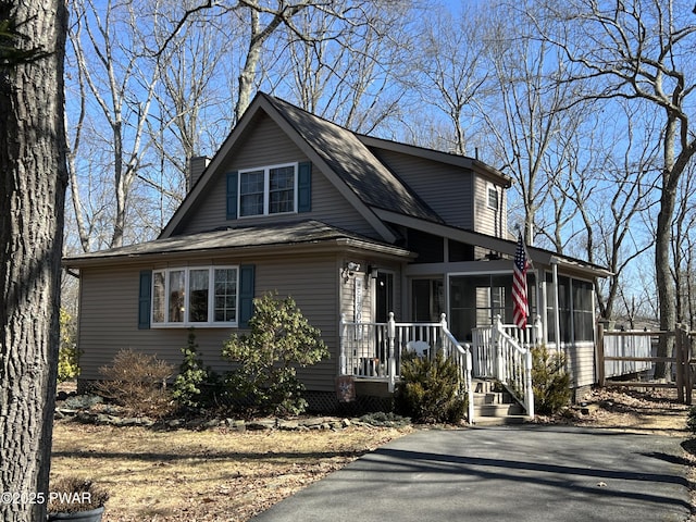 view of front of house with a sunroom and a chimney