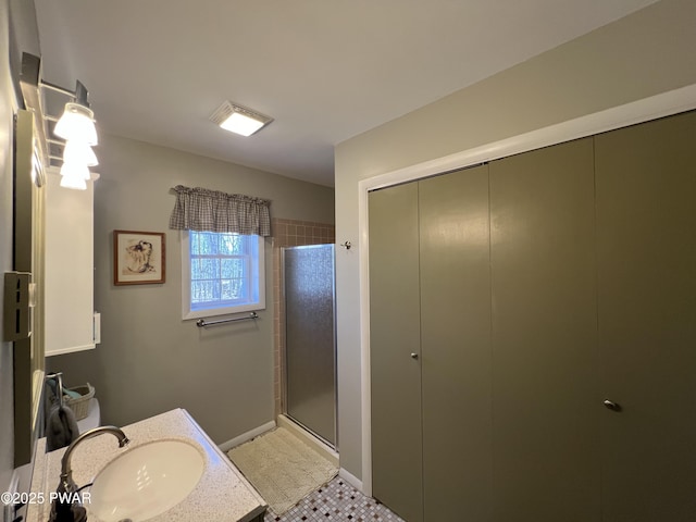 full bathroom with baseboards, a stall shower, and vanity