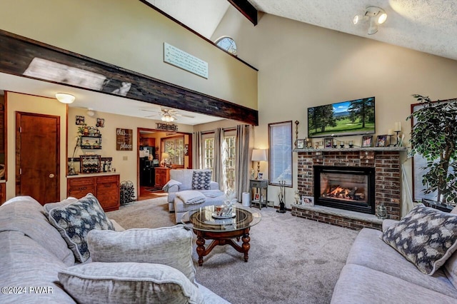 carpeted living room with ceiling fan, a fireplace, lofted ceiling with beams, and a textured ceiling