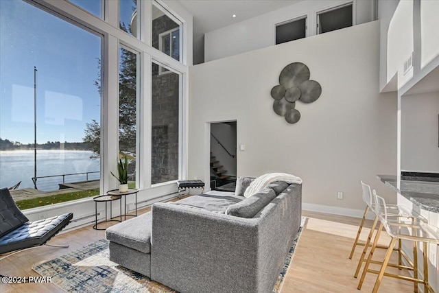 living room featuring light hardwood / wood-style flooring and a water view