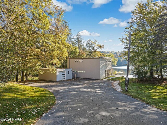 view of property exterior featuring a water view and a yard