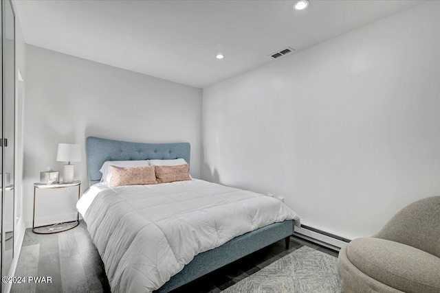 bedroom with hardwood / wood-style flooring and a baseboard radiator