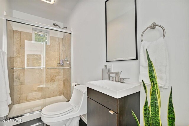 bathroom featuring vanity, toilet, and a shower with door