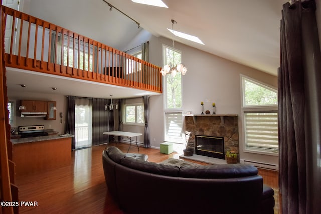 139 Westwood Dr, Dingmans Ferry, PA 18328 - living area featuring a baseboard radiator, a skylight, wood finished floors, a baseboard heating unit, and high vaulted ceiling
