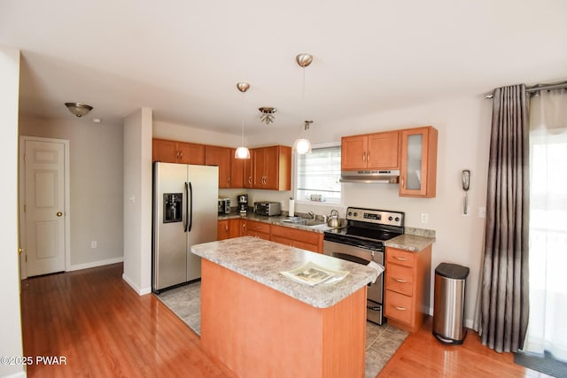 139 Westwood Dr, Dingmans Ferry, PA 18328 - kitchen with appliances with stainless steel finishes, under cabinet range hood, light countertops, light wood-style flooring, and pendant lighting