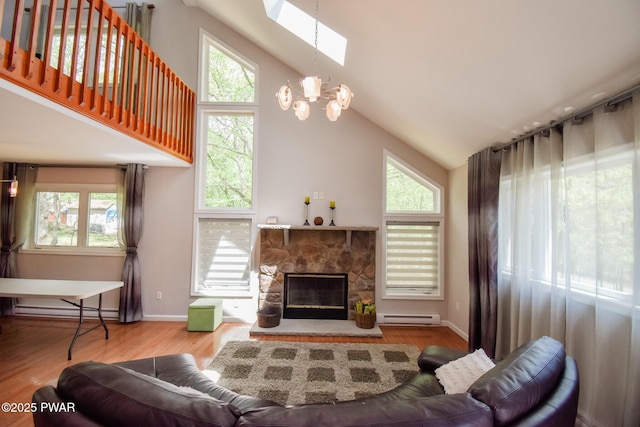 139 Westwood Dr, Dingmans Ferry, PA 18328 - living area featuring a baseboard radiator, a skylight, a chandelier, a fireplace, and wood finished floors