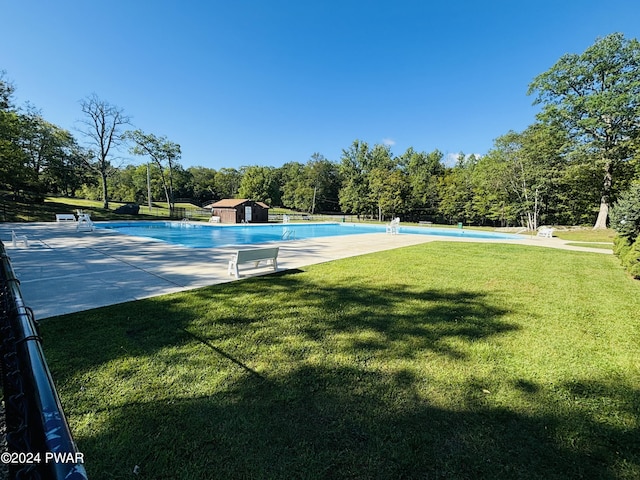 view of swimming pool with a lawn