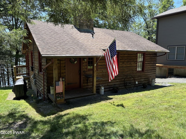 22 Glen Rd, Lake Ariel, PA 18436 - view of front facade featuring a chimney, a front yard, a shingled roof, and log siding