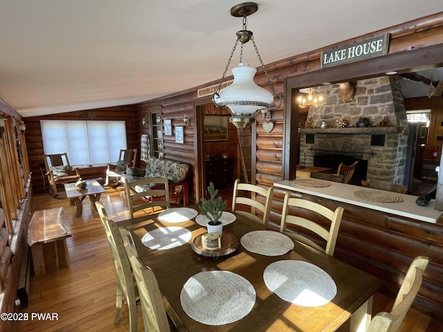 22 Glen Rd, Lake Ariel, PA 18436 - dining space with rustic walls, hardwood / wood-style flooring, vaulted ceiling, and a fireplace