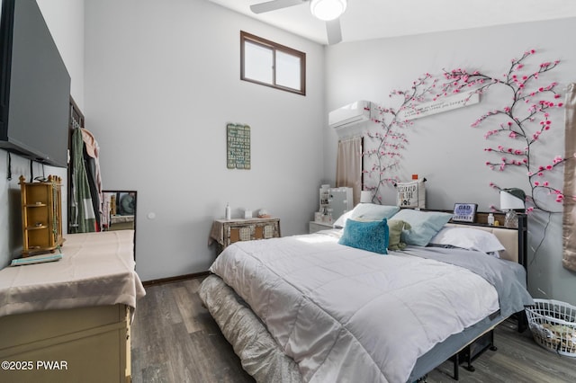 bedroom with baseboards, an AC wall unit, a ceiling fan, and wood finished floors