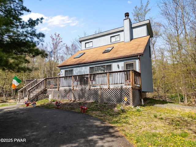 view of front of house featuring a chimney and a deck