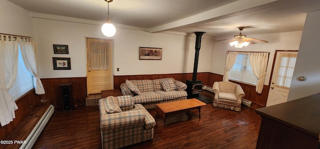 640 Rte 434, Shohola, PA 18458 - living area with a baseboard radiator, a wainscoted wall, wooden walls, a wood stove, and wood finished floors