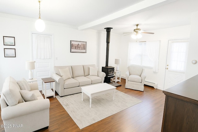 640 Rte 434, Shohola, PA 18458 - living room featuring ceiling fan, a wood stove, baseboard heating, dark wood finished floors, and beamed ceiling