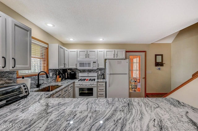 98 Roamingwood Rd, Lake Ariel, PA 18436 - kitchen featuring light stone counters, a sink, decorative backsplash, white appliances, and recessed lighting