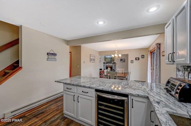 98 Roamingwood Rd, Lake Ariel, PA 18436 - kitchen featuring a peninsula, wine cooler, dark wood-style floors, light stone countertops, and a baseboard radiator