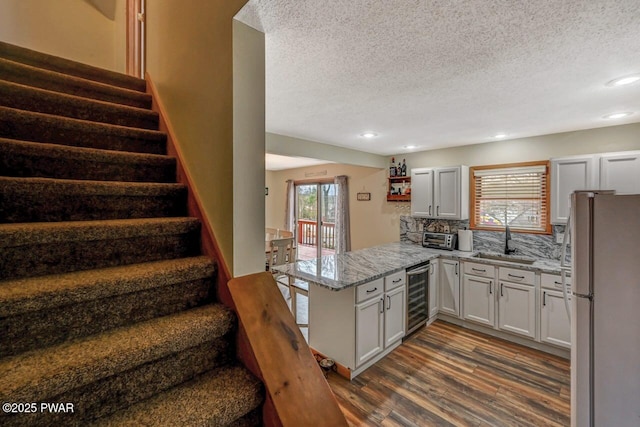 98 Roamingwood Rd, Lake Ariel, PA 18436 - kitchen featuring a sink, beverage cooler, a peninsula, dark wood-style flooring, and freestanding refrigerator