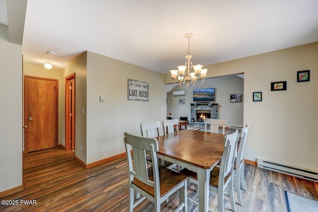 98 Roamingwood Rd, Lake Ariel, PA 18436 - dining area featuring baseboard heating, wood finished floors, a chandelier, a fireplace, and baseboards