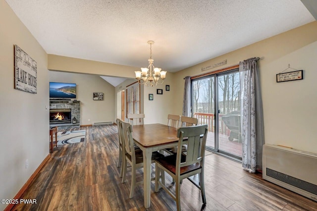 98 Roamingwood Rd, Lake Ariel, PA 18436 - dining space with baseboard heating, a stone fireplace, wood finished floors, a textured ceiling, and a chandelier